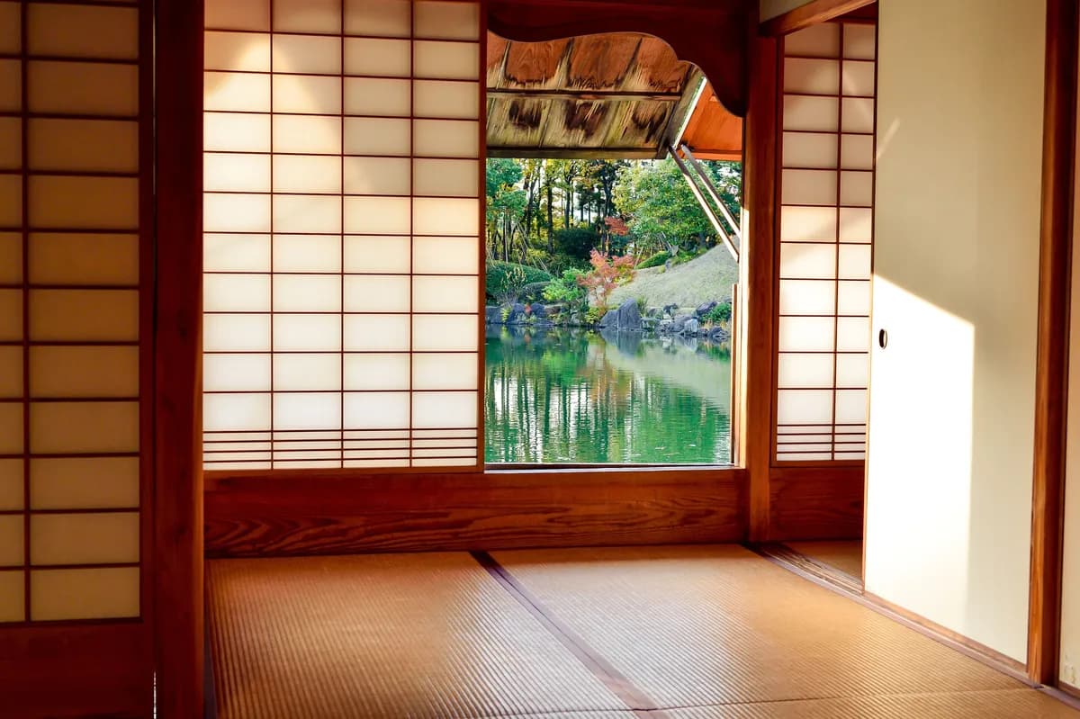 BookNoFees Imagem de exemplo: sala japonesa com portas deslizantes e vista para um lago no jardim