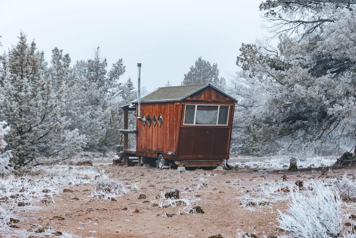 BookNoFees Imagem de exemplo: pequena cabana de madeira sobre rodas em uma paisagem coberta de neve