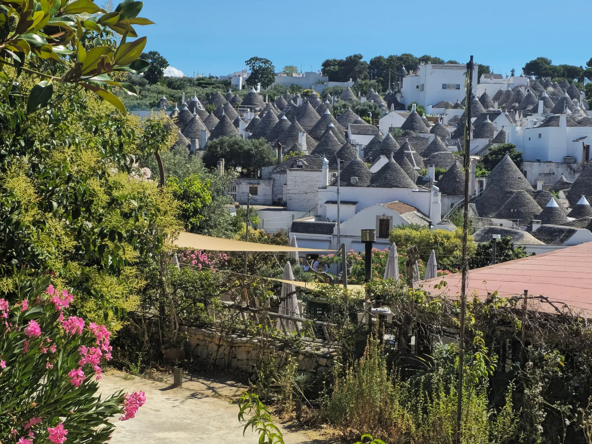 BookNoFees Imagem de exemplo: Trulli brancos com telhados cônicos de pedra e jardins