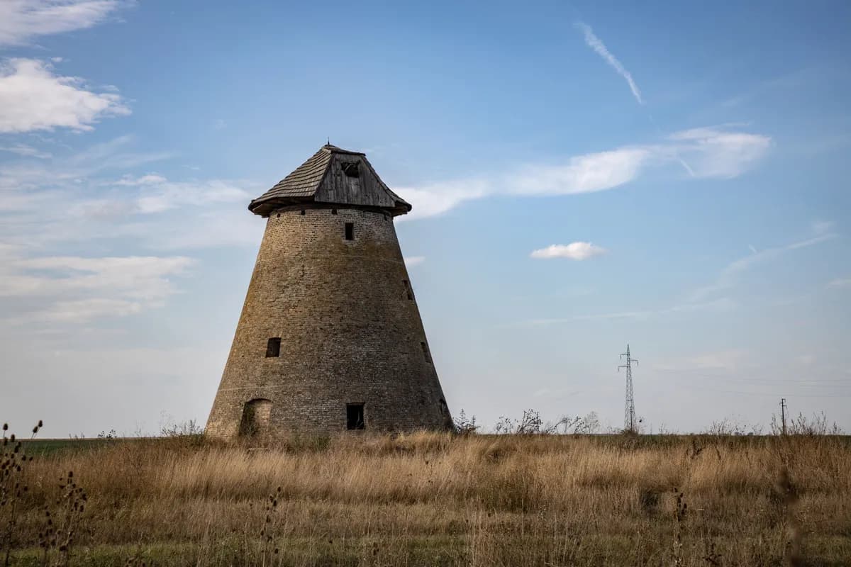 BookNoFees Imagem de exemplo: Torre de moinho de pedra sem asas em um prado