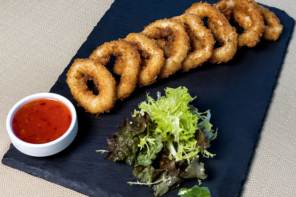 BookNoFees: Fotografia ilustrativa: Argolas de lula fritas com salada e molho