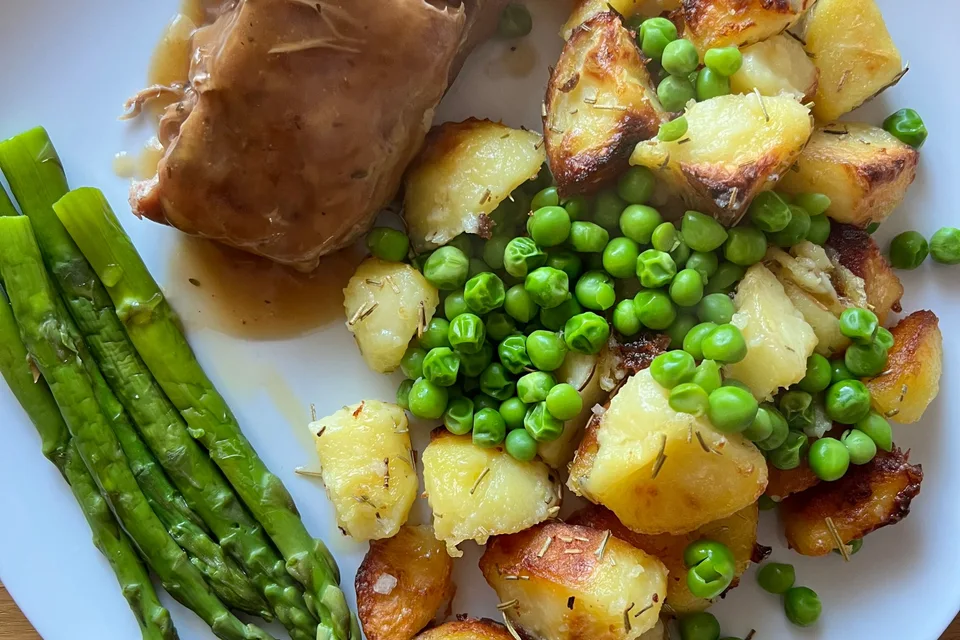 BookNoFees: Fotografia ilustrativa: Porco assado com molho de carne, batatas assadas, ervilhas e espargos