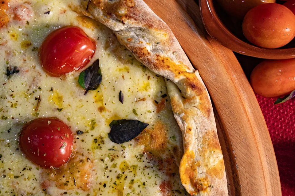 BookNoFees: Fotografia ilustrativa: Pizza de queijo com tomate-cereja
