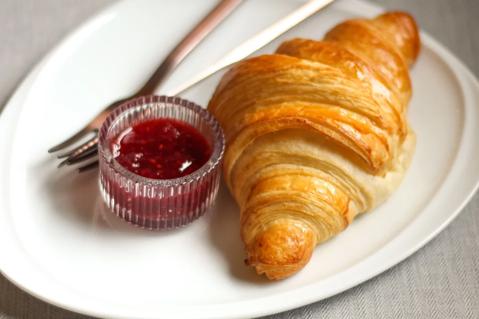 BookNoFees: Fotografia ilustrativa: Croissant servido com compota