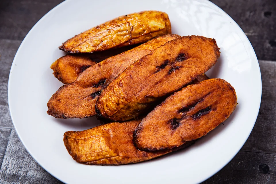 BookNoFees: Fotografia ilustrativa: Rodelas de banana-pão fritas num prato branco