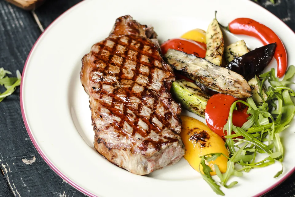 BookNoFees: Fotografia ilustrativa: Bife grelhado servido com legumes