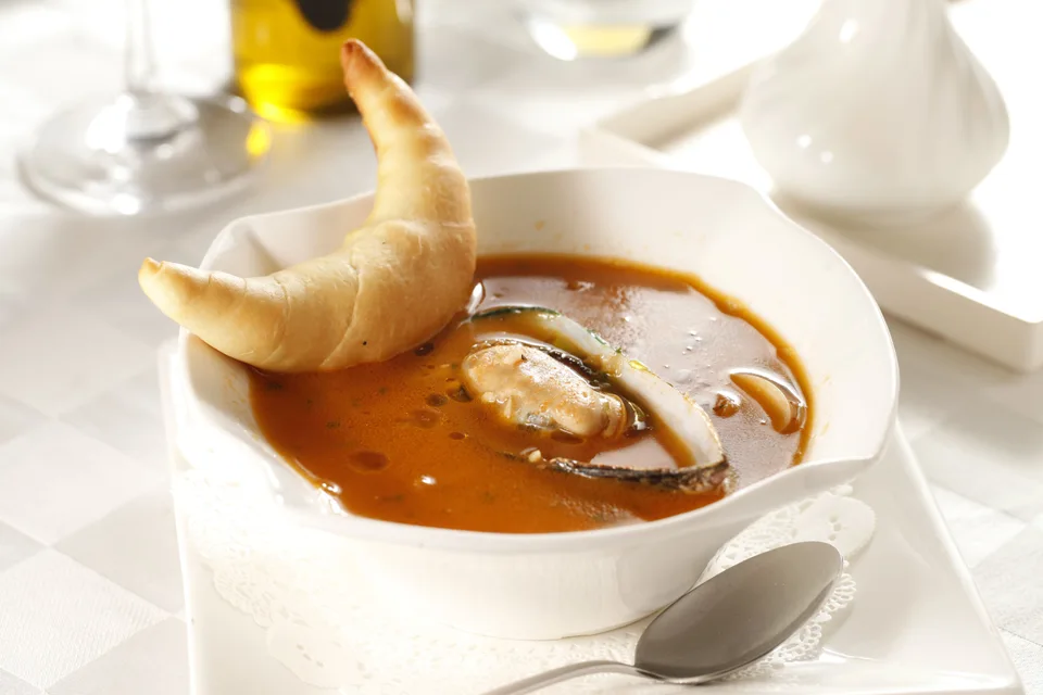 BookNoFees: Fotografia ilustrativa: Sopa de marisco servida com pão