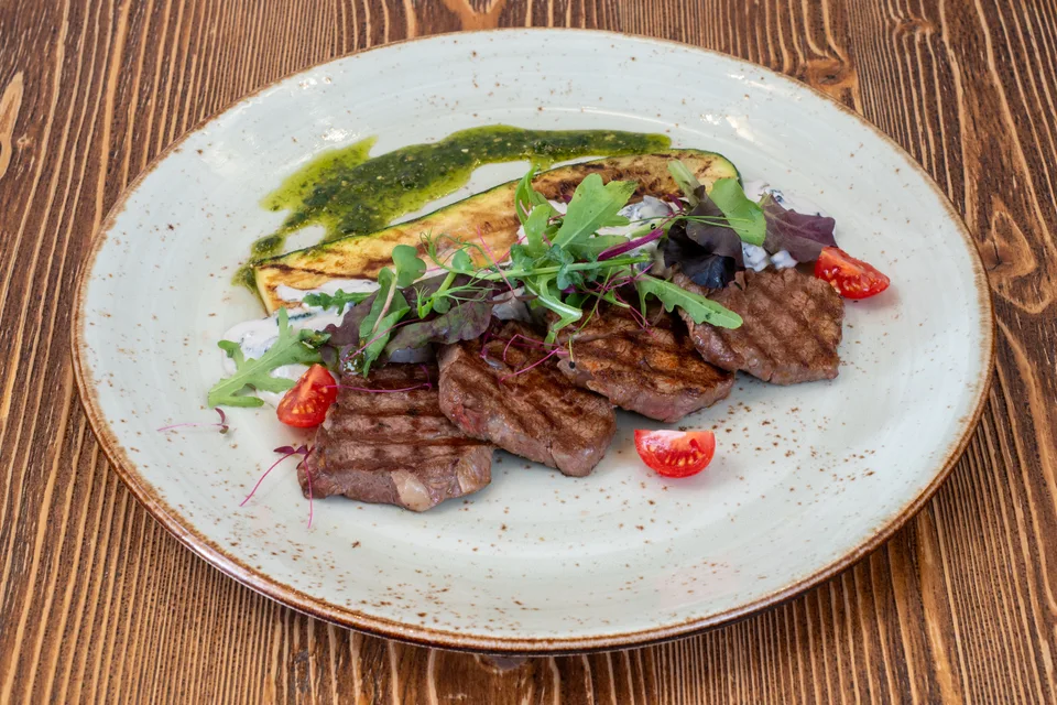 BookNoFees: Fotografia ilustrativa: Bife fatiado servido com legumes